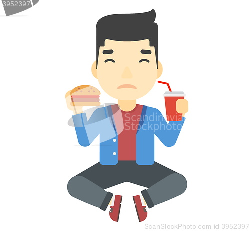 Image of Man eating hamburger. 