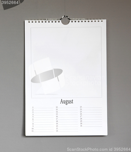 Image of Simple old birthday calendar hanging on a grey wall - August