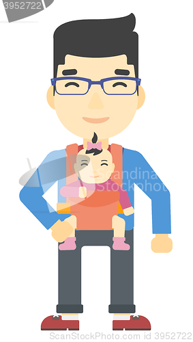 Image of Man holding baby in sling.