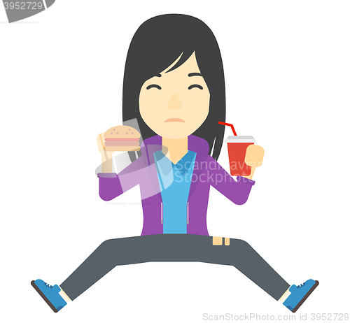 Image of Woman eating hamburger. 