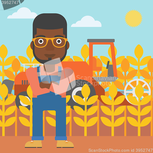 Image of Man standing with combine on background.