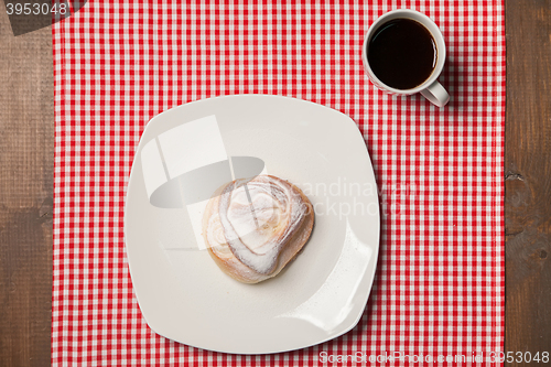 Image of Coffee and sweet cupcake on checkered napkin