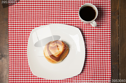 Image of Coffee and sweet cupcake on checkered napkin