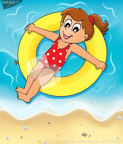 Image of Girl on swim ring at seashore