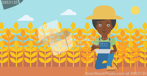 Image of Farmer with tablet computer on field.