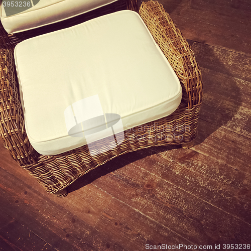 Image of Retro style rattan armchair on wooden floor