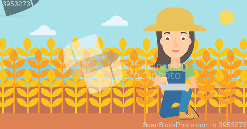 Image of Farmer with tablet computer on field.