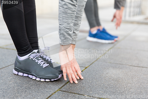 Image of close up of couple stretching on city street