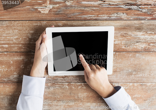 Image of close up of female hands with tablet pc on table