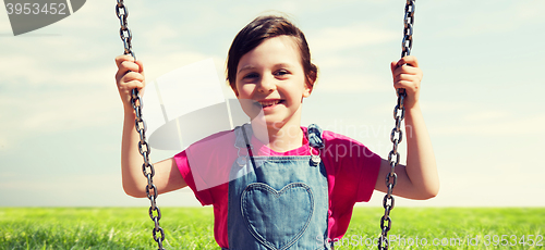 Image of happy little girl swinging on swing outdoors