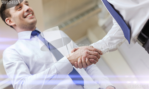 Image of two businessmen shaking hands in office