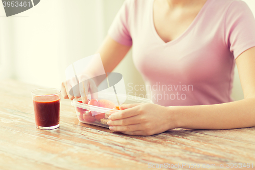 Image of close up of woman with food in plastic container