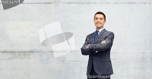 Image of happy smiling businessman over gray concrete wall 