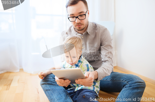 Image of father and son with tablet pc playing at home