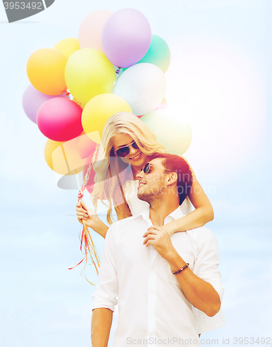 Image of couple in sunglases with colorful balloons