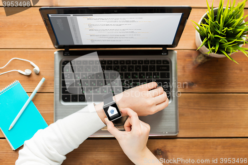 Image of close up of woman with smart watch and laptop