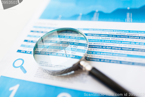 Image of close up of financial report and magnifying glass