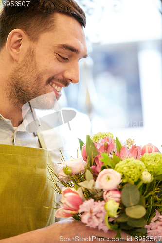 Image of smiling florist man making bunch at flower shop