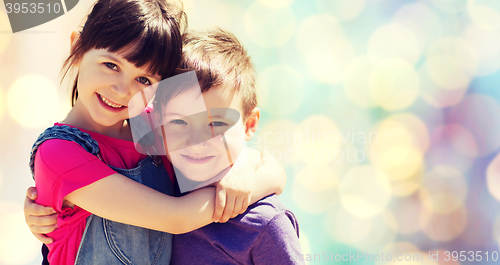 Image of two happy kids hugging over blue lights background