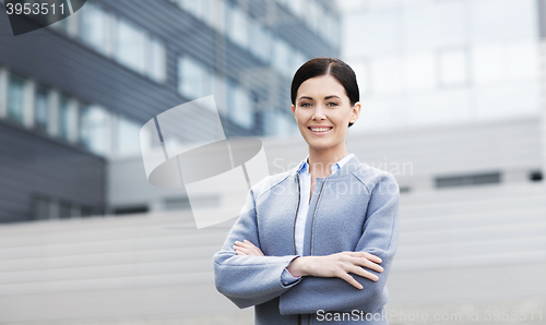 Image of young smiling businesswoman over office building