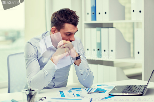 Image of stressed businessman with laptop and papers