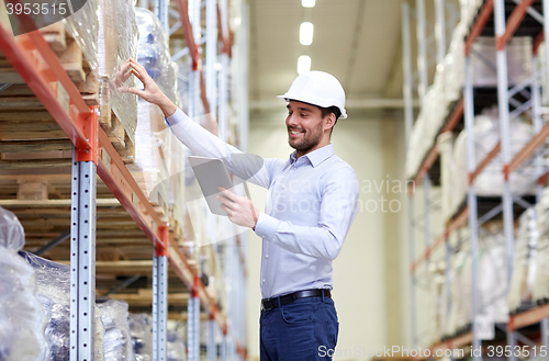 Image of happy businessman with tablet pc at warehouse