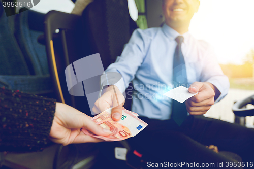 Image of close up of bus driver selling ticket to passenger