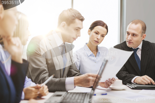 Image of business team with laptop having discussion