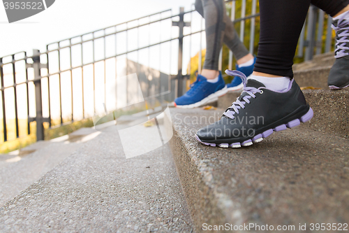 Image of close up of feet running downstairs in city