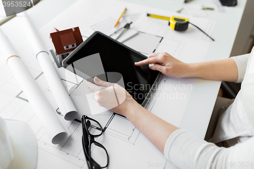 Image of close up of hand with blueprint and tablet pc