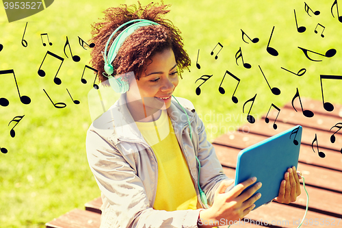 Image of happy african woman in headphones with tablet pc