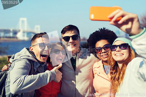 Image of happy friends taking selfie with smartphone