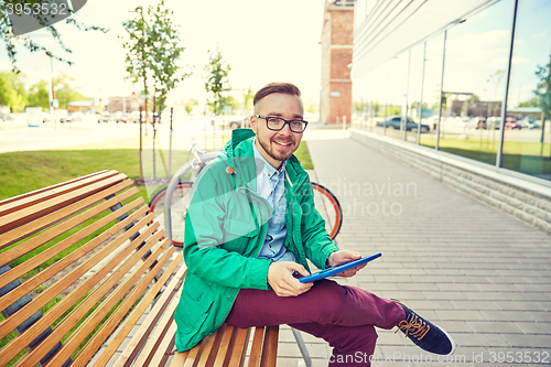 Image of happy young hipster man with tablet pc and bike