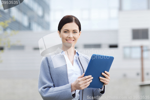 Image of smiling business woman with tablet pc in city