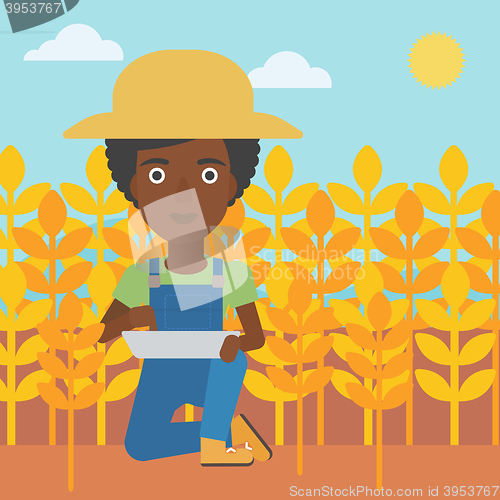 Image of Farmer with tablet computer on field.