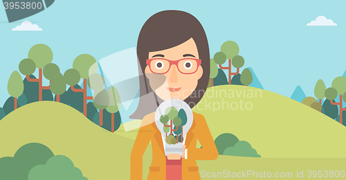 Image of Woman with lightbulb and trees inside.