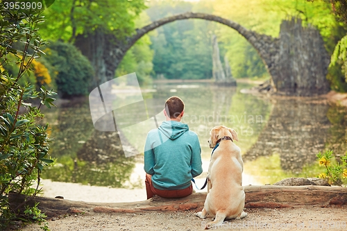 Image of Pensive man sitting with his dog