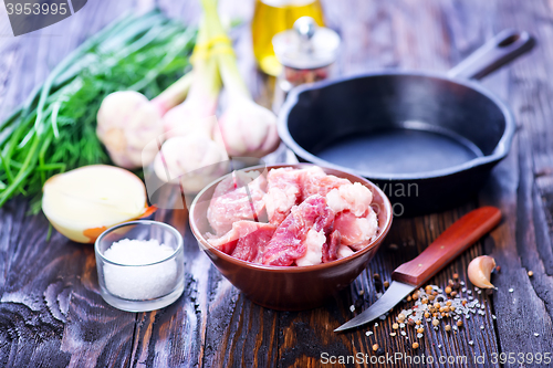 Image of raw meat and pan on a table