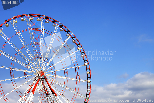 Image of Ferris wheel and blue sky with clouds