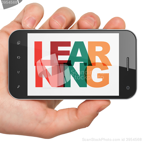 Image of Studying concept: Hand Holding Smartphone with Learning on  display