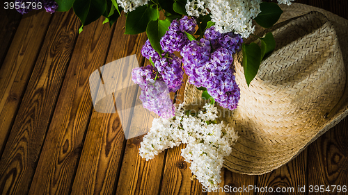 Image of Bouquet of lilacs and a straw hat