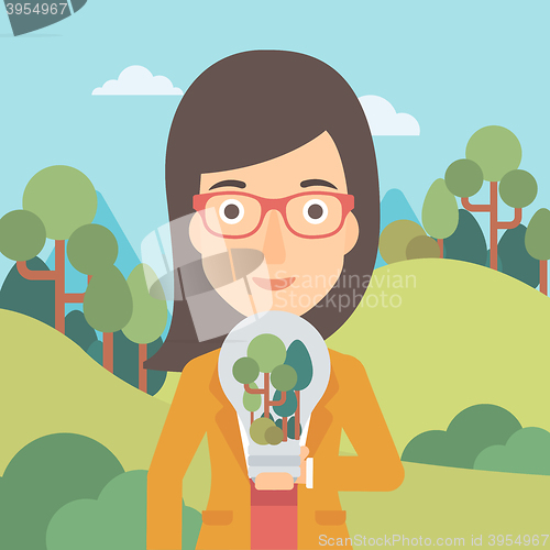 Image of Woman with lightbulb and trees inside.