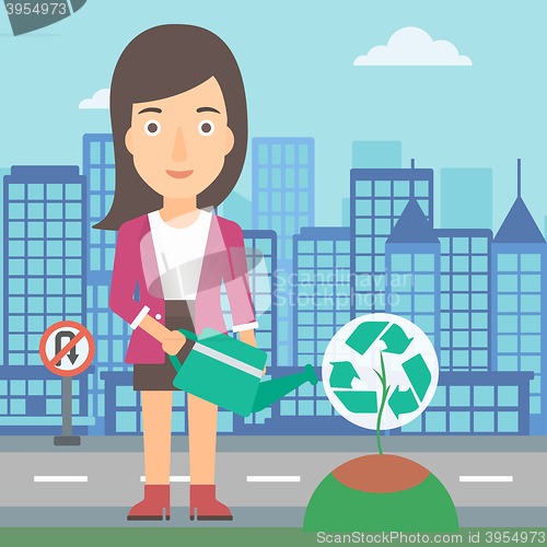 Image of Woman watering tree with recycle sign instead of crown.