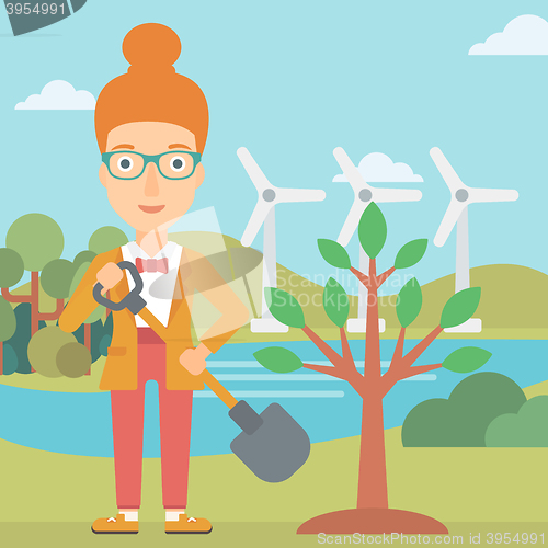 Image of Woman plants tree.