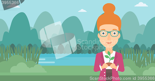 Image of Woman holding plant.