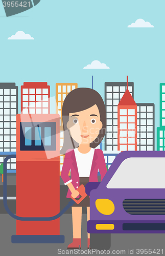 Image of Woman filling up fuel into car.