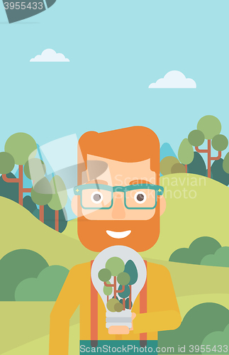 Image of Man with lightbulb and trees inside.