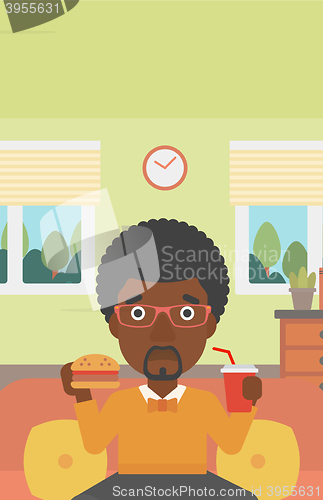 Image of Man eating hamburger. 