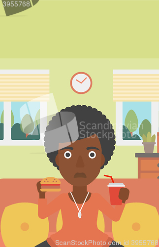 Image of Woman eating hamburger. 