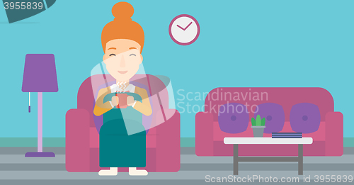 Image of Woman sitting in chair with cup of tea.